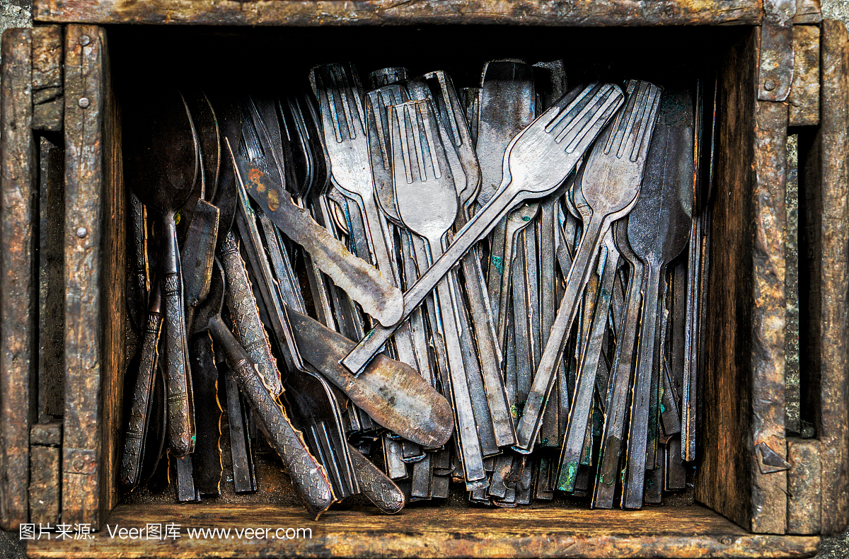 在青铜餐具厂的木盒中手工制作勺子和叉子的青铜餐具,形象为工业背景